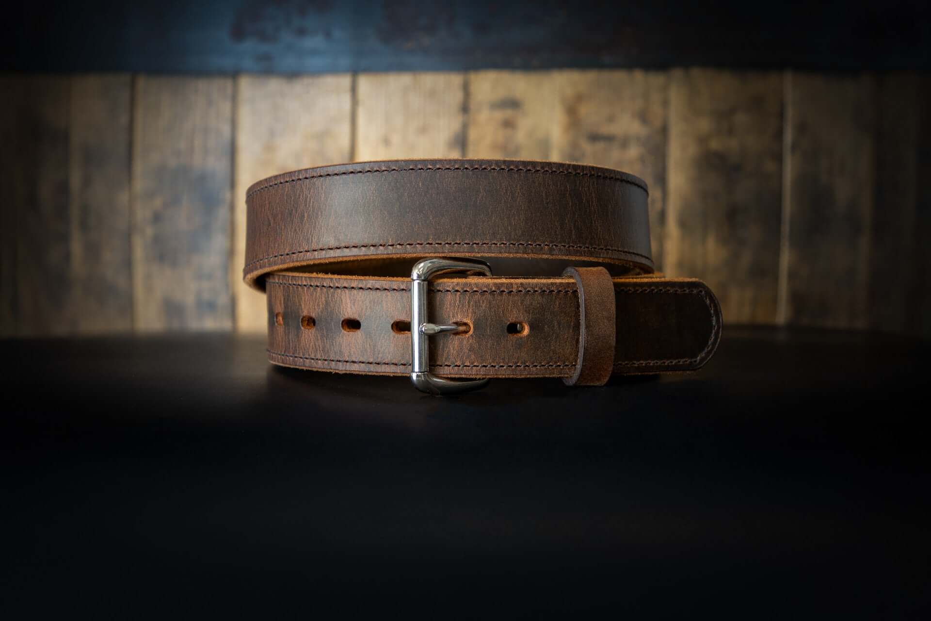 A brown leather belt rolled up.