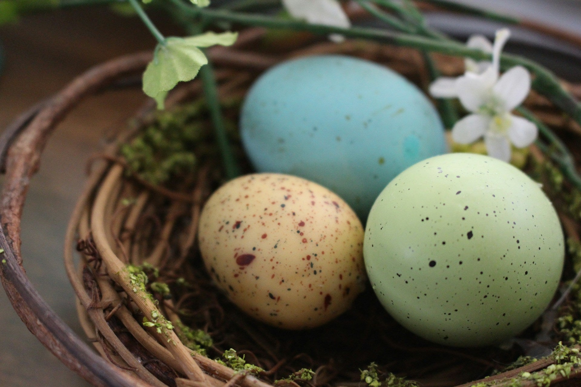 Three pastel eggs in a nest-like basket.