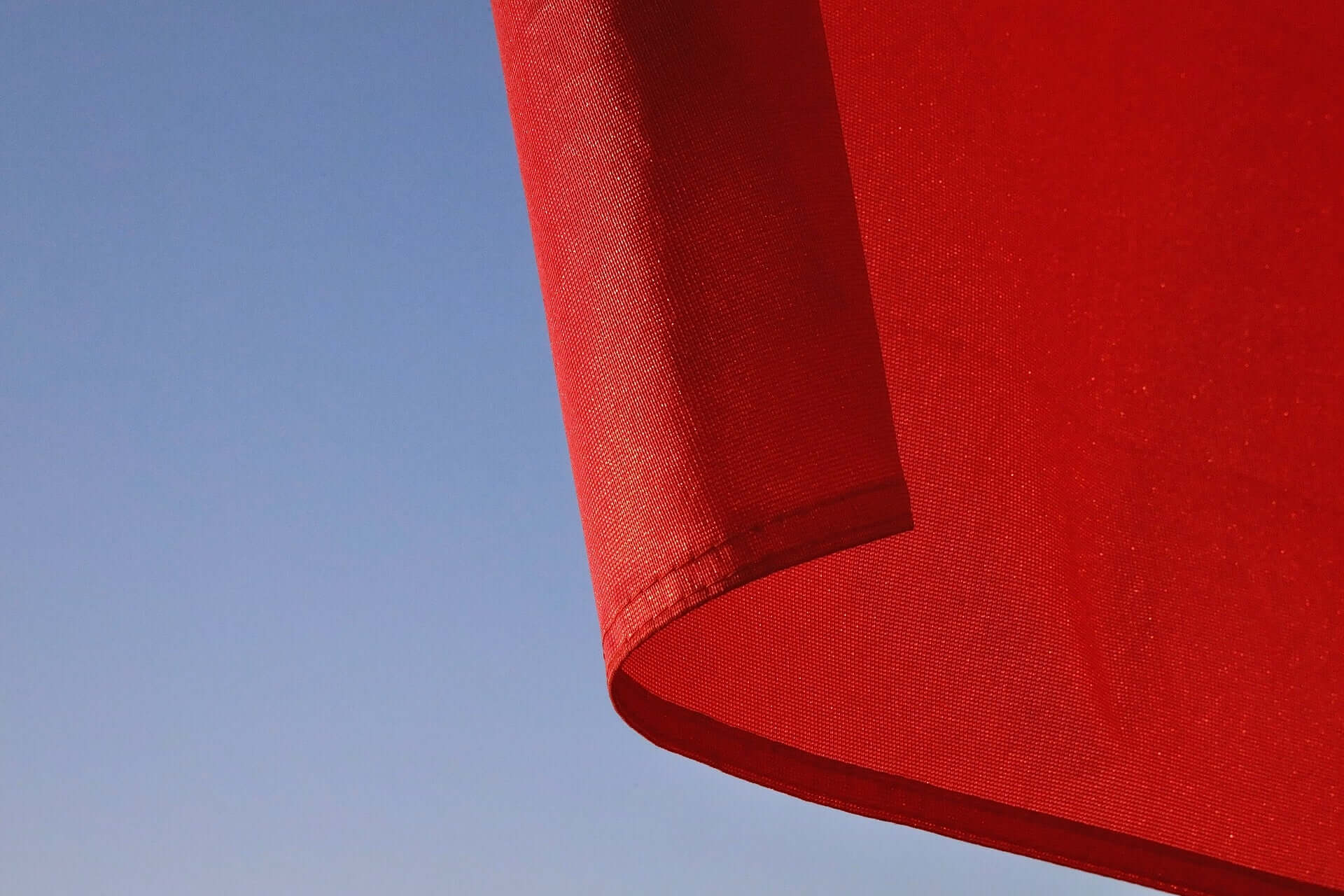 The corner of a red flag on a blue background.