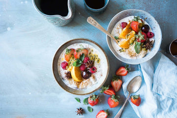 Two bowls of fruit and non-dairy yogurt.