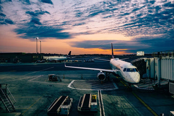 An airplane being loaded at sunset.