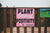 A pink sign on a wooden fence reads "Plant Seeds of Positivity."