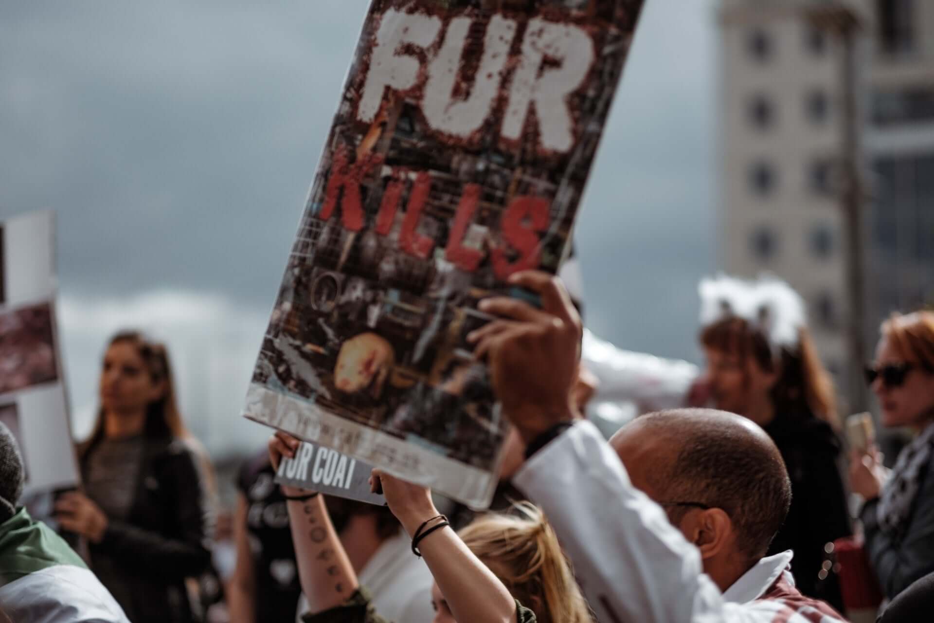 Protesters hold a sign that says "Fur kills."