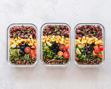 Three pre-prepared lunches full of vegetables and rice.