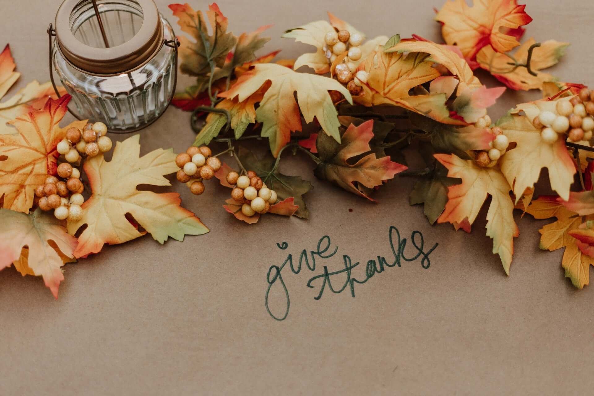 Autumn leaves with the text "give thanks" in cursive.