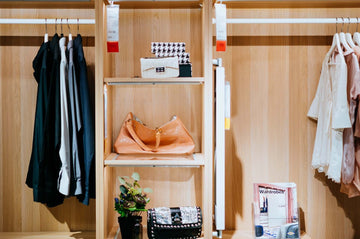 A wooden closet with some women's clothing and accessories.