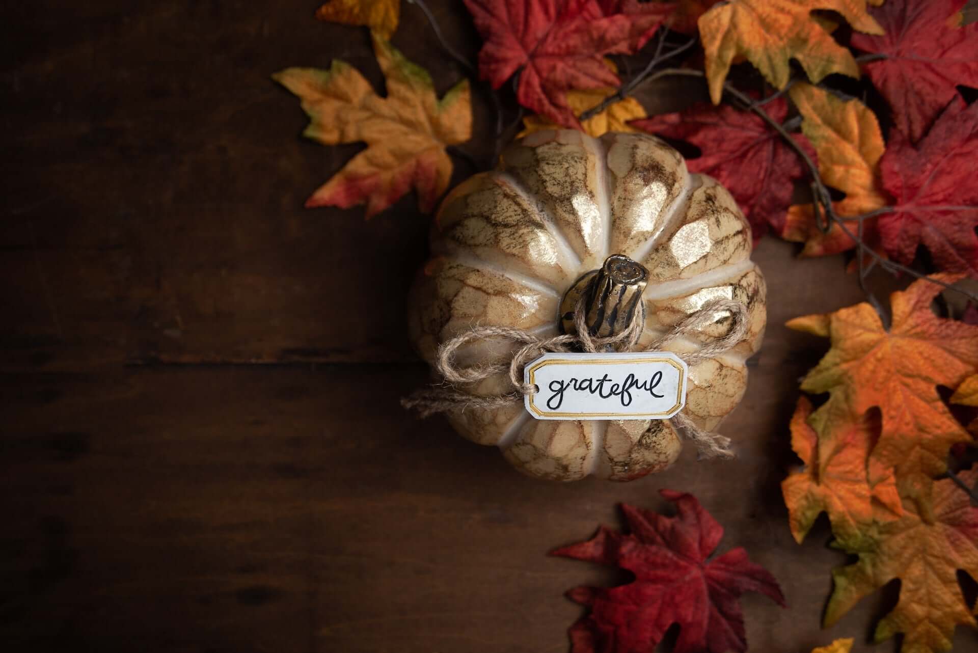A decorative gold pumpkin with a small label reading "grateful" in looping script.