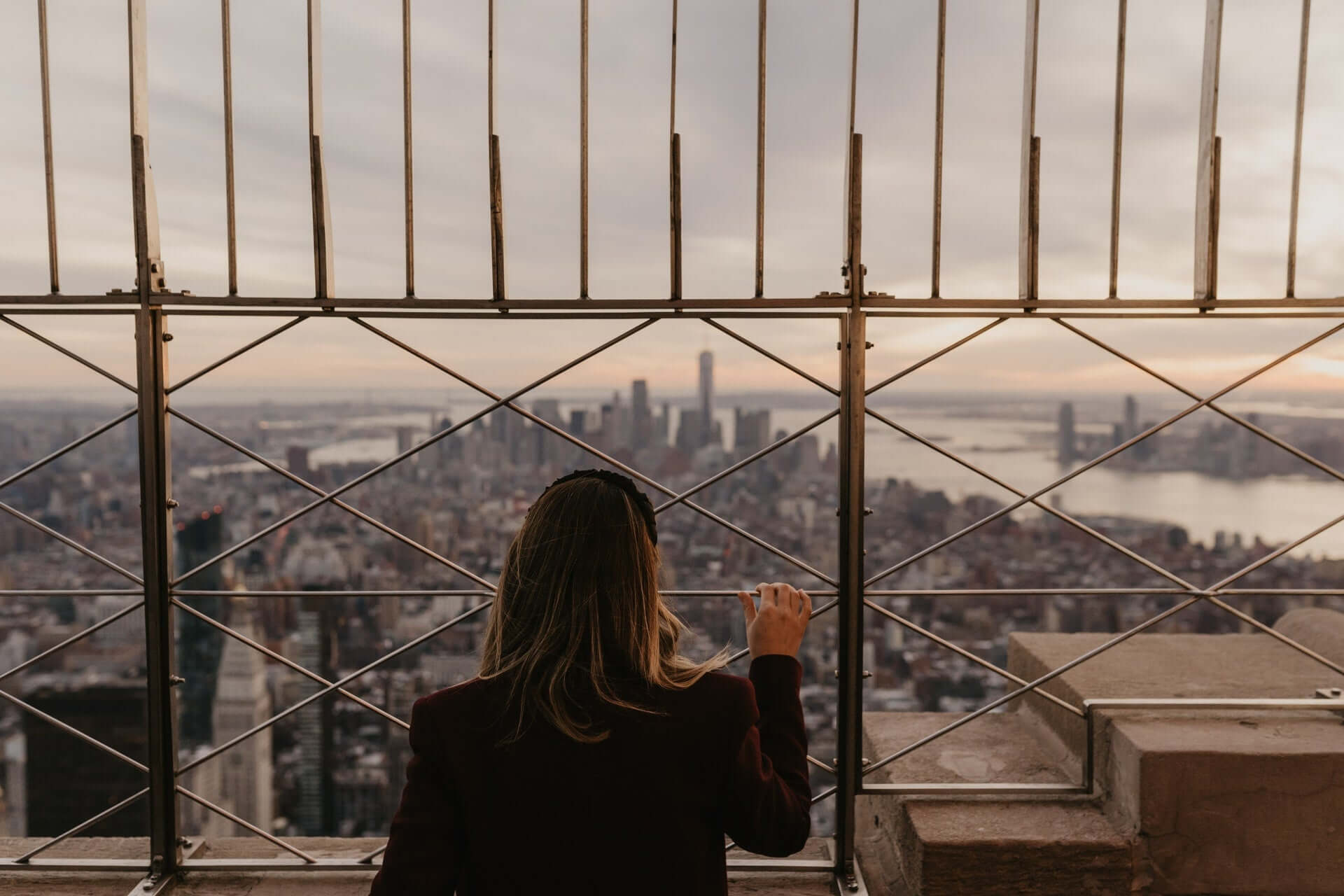 A woman looks at the New York City skyline from a tall position.