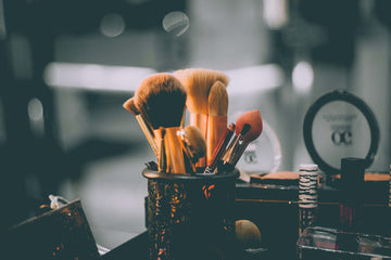 Makeup brushes in a dark-colored cup.