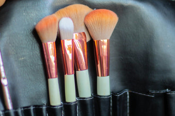 White and orange makeup brushes in a black case.