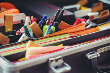 The interior of a filing briefcase, full of multicolored stationary.