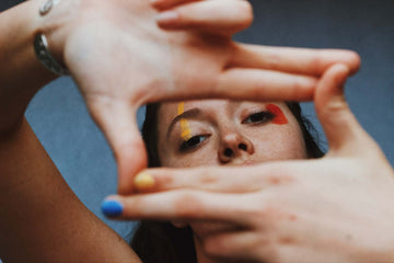 A woman holds her hands in front of her face like a frame.