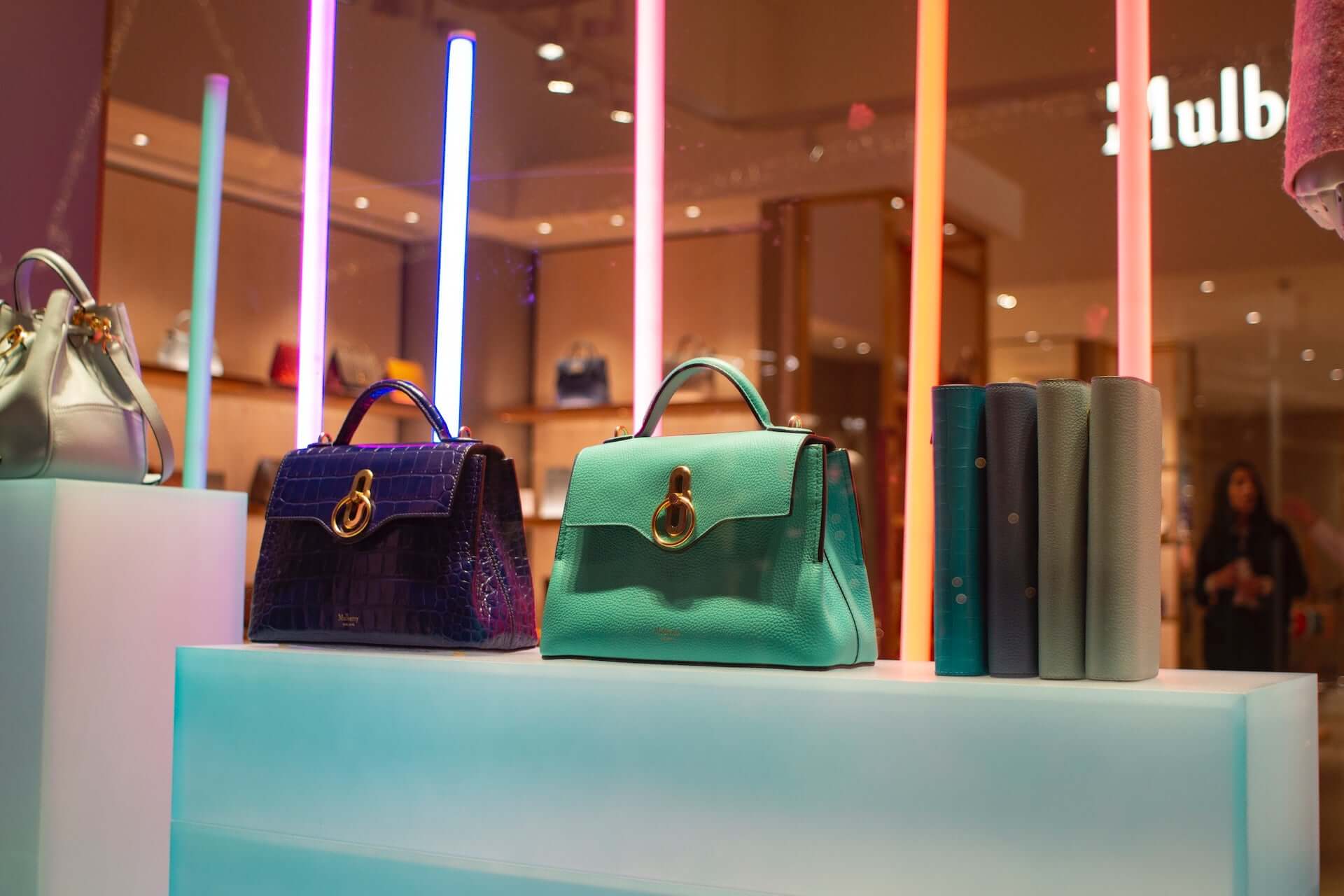 Green and purple handbags on display.