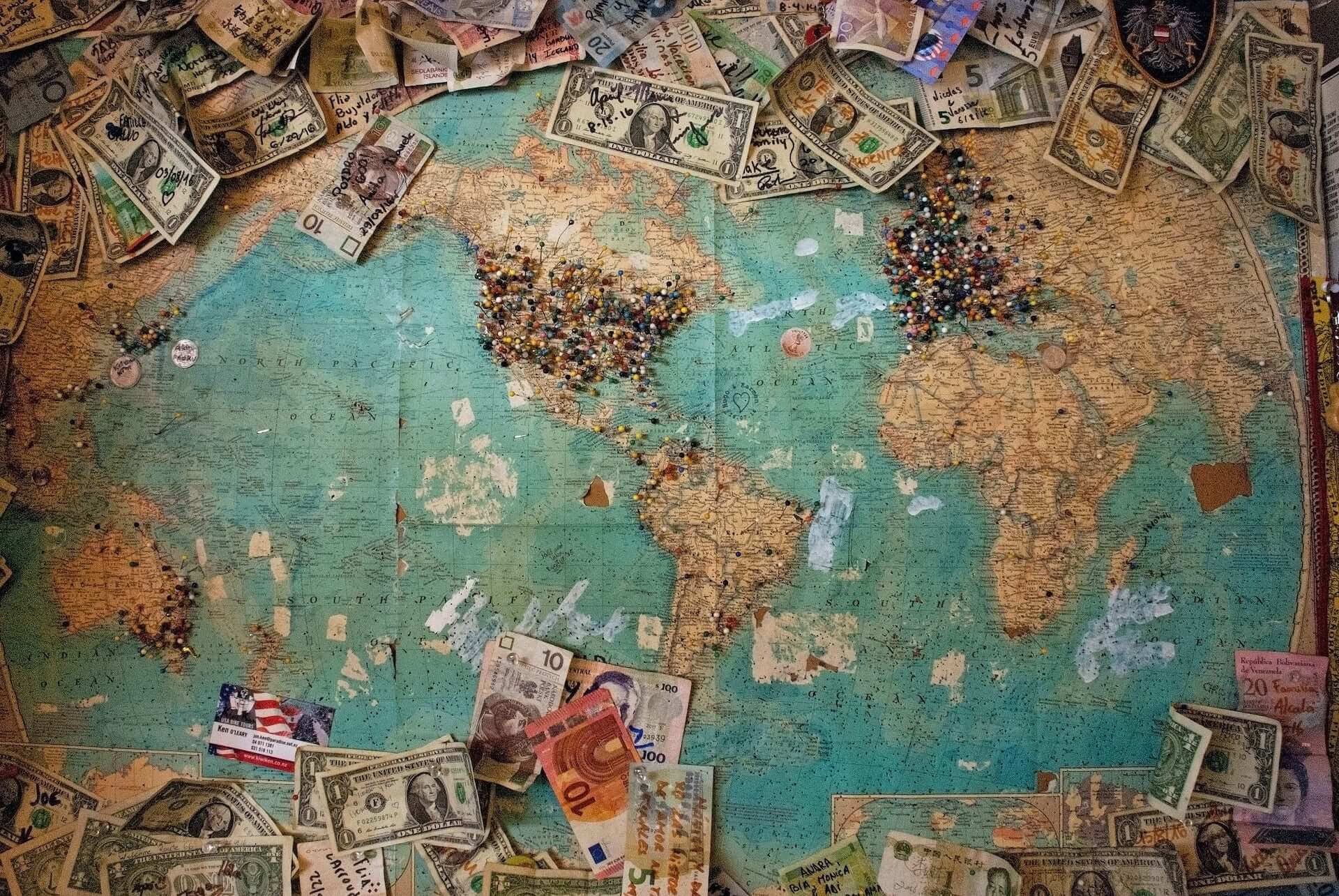 A map of the world surrounded by currency, tickets, and other trinkets.