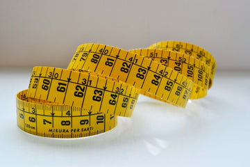 A yellow flexible measuring tape wound in spirals.