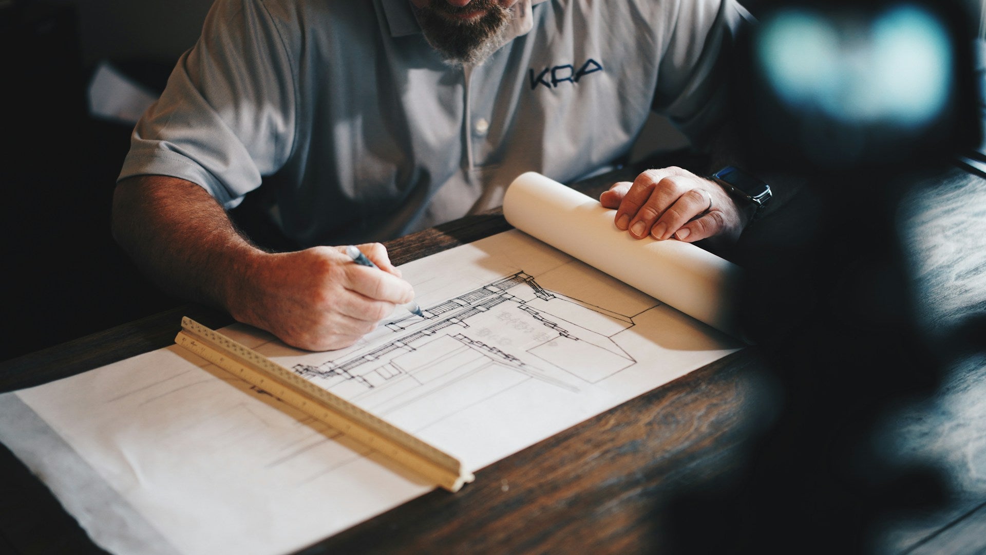 A man works on a schematic for a building.