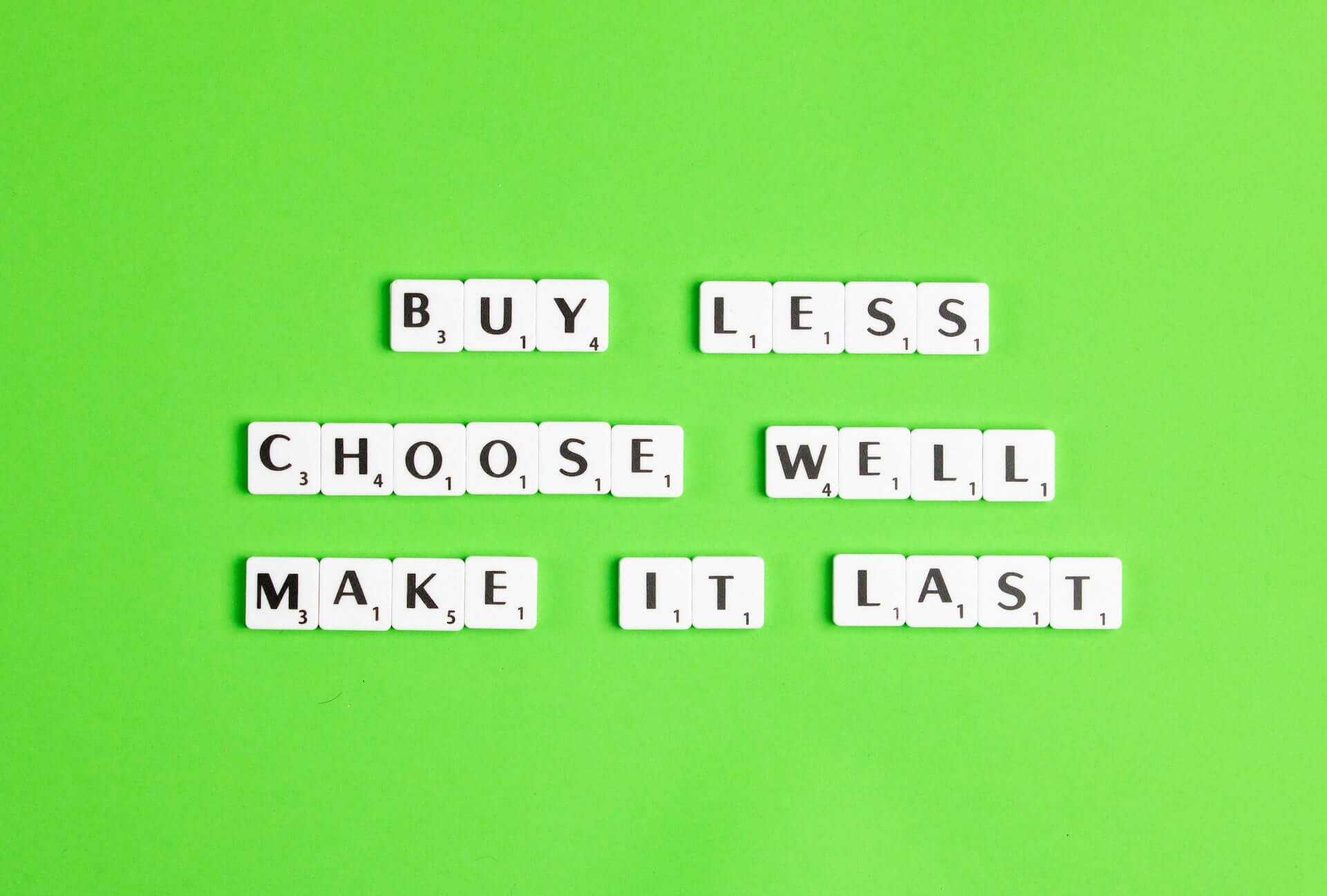 Scrabble tiles that read, "Buy less, choose well, make it last."