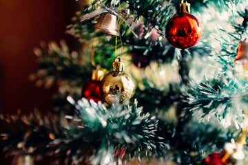 Close shot of a Christmas tree decorated with red and gold baubles.