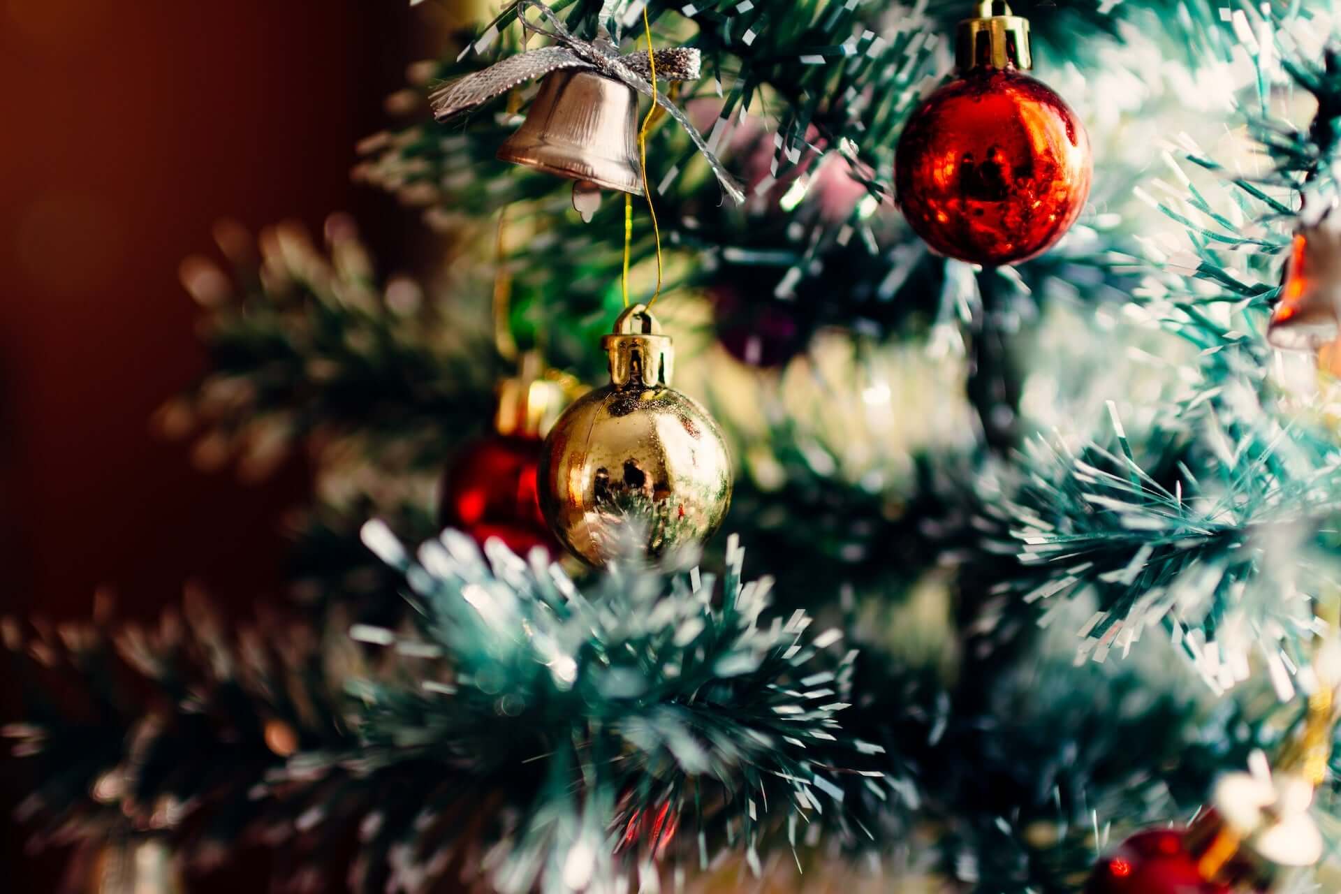 Close shot of a Christmas tree decorated with red and gold baubles.