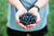 A person holds blueberries cupped in both hands.