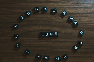 Letter tiles arranged in a circle around tiles that spell out "June."