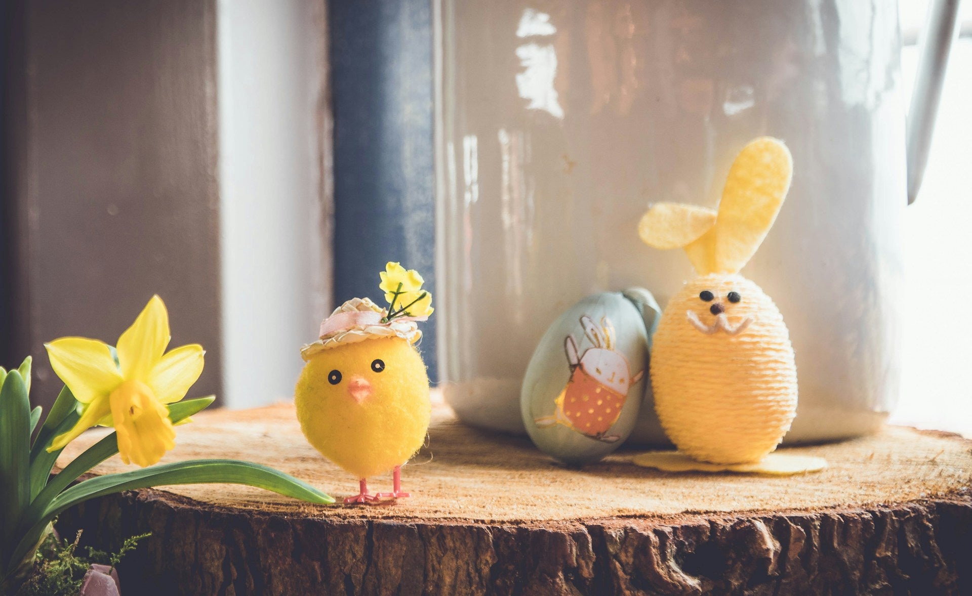 Easter eggs, one decorated like a bunny, and a small toy chick. 