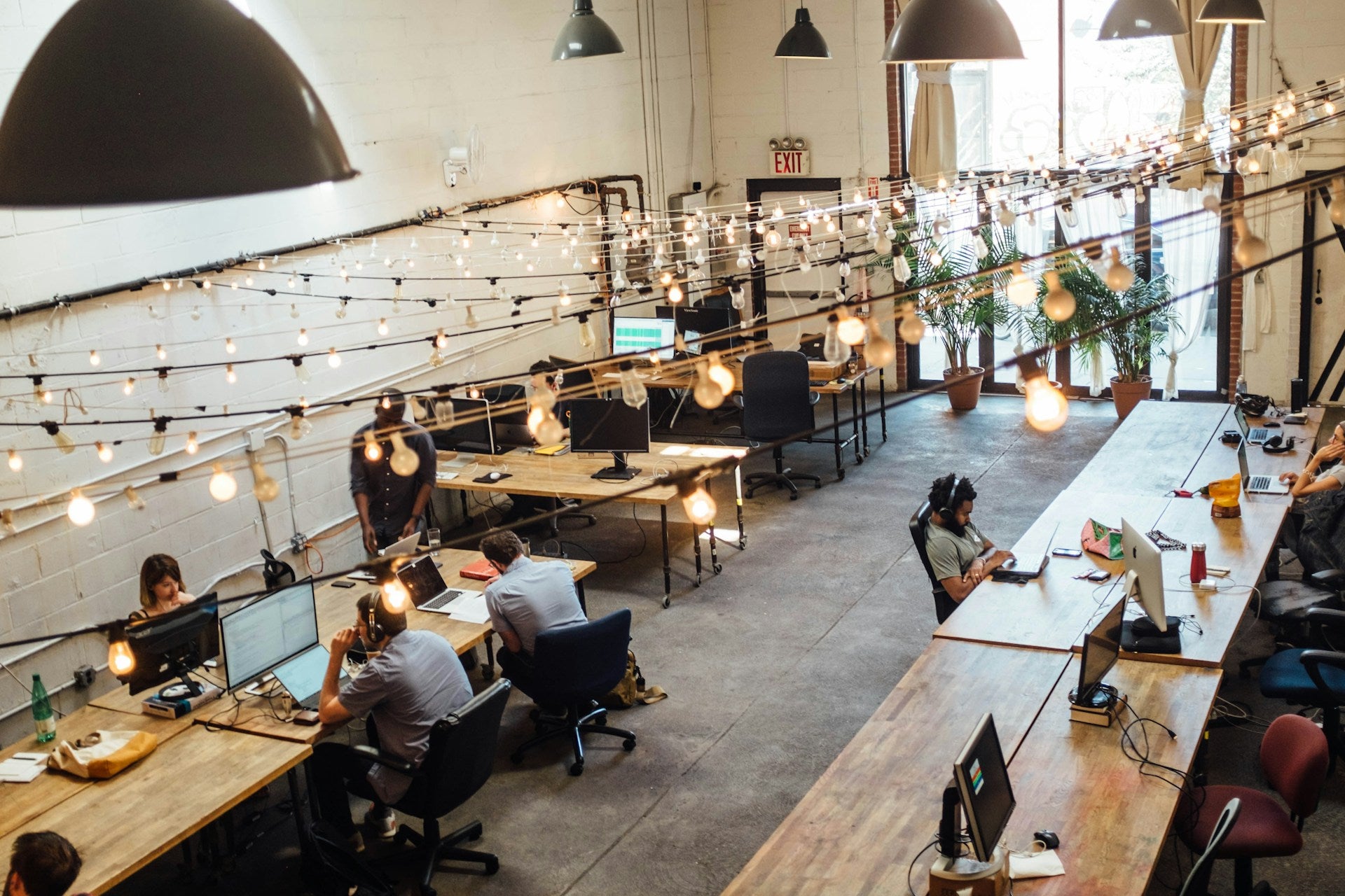 Overhead shot of an open plan office with people working at various computers and laptops.