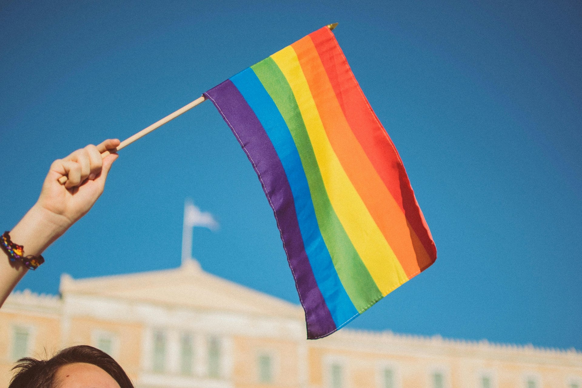 A rainbow pride flag being waved.